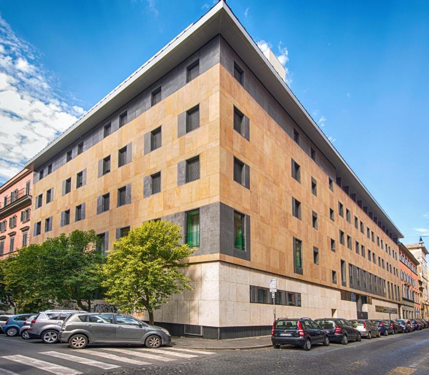 a large building with cars parked in a parking lot at Domus Helena in Rome