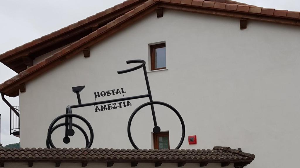 een bord aan de zijkant van een gebouw met een fiets erop bij Hostal Ameztia in Doneztebe