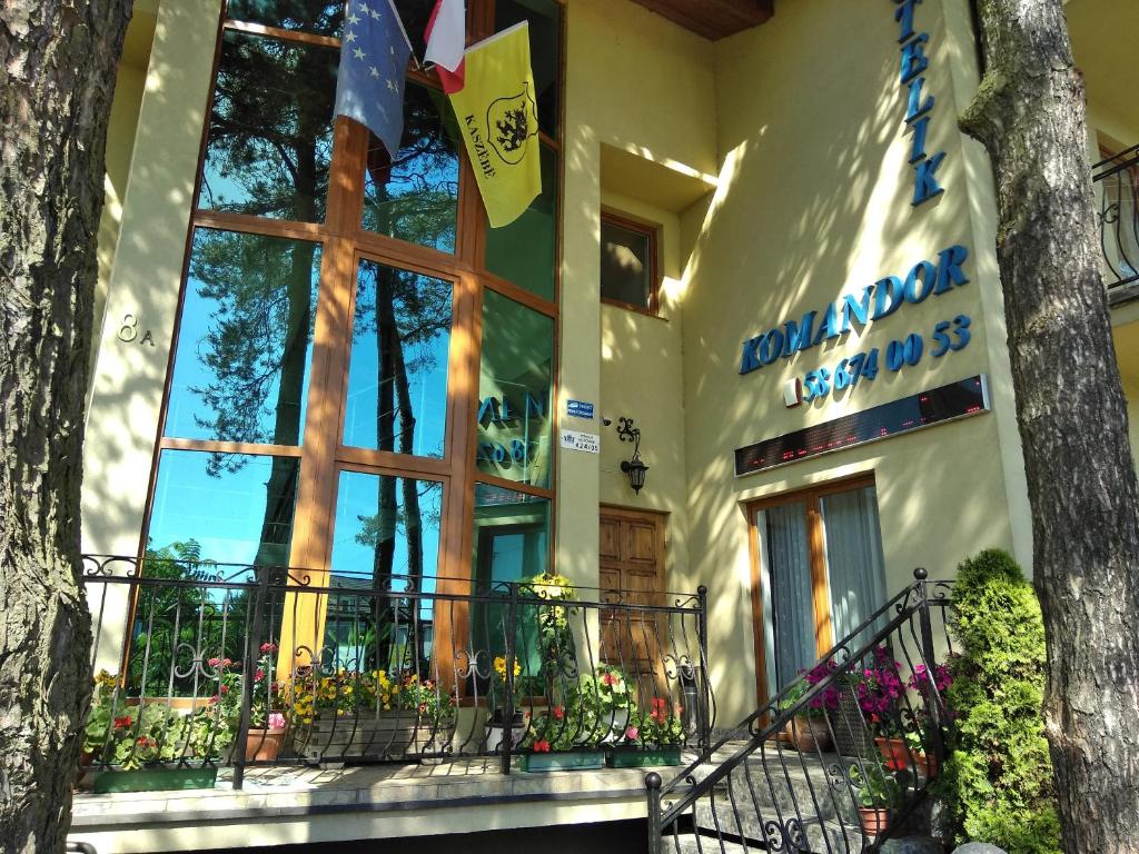 a building with a sign on the side of it at Hotelik Komandor in Władysławowo