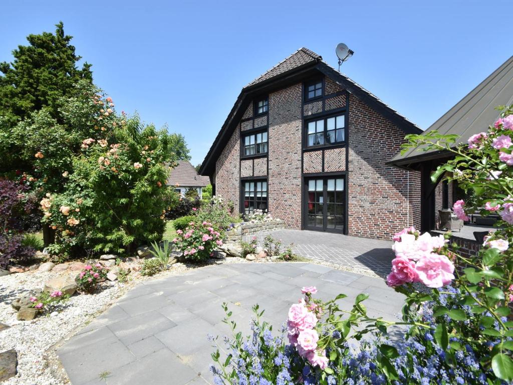 a brick house with flowers in front of it at Spacious Mansion with Meadow View in Bruinisse in Bruinisse