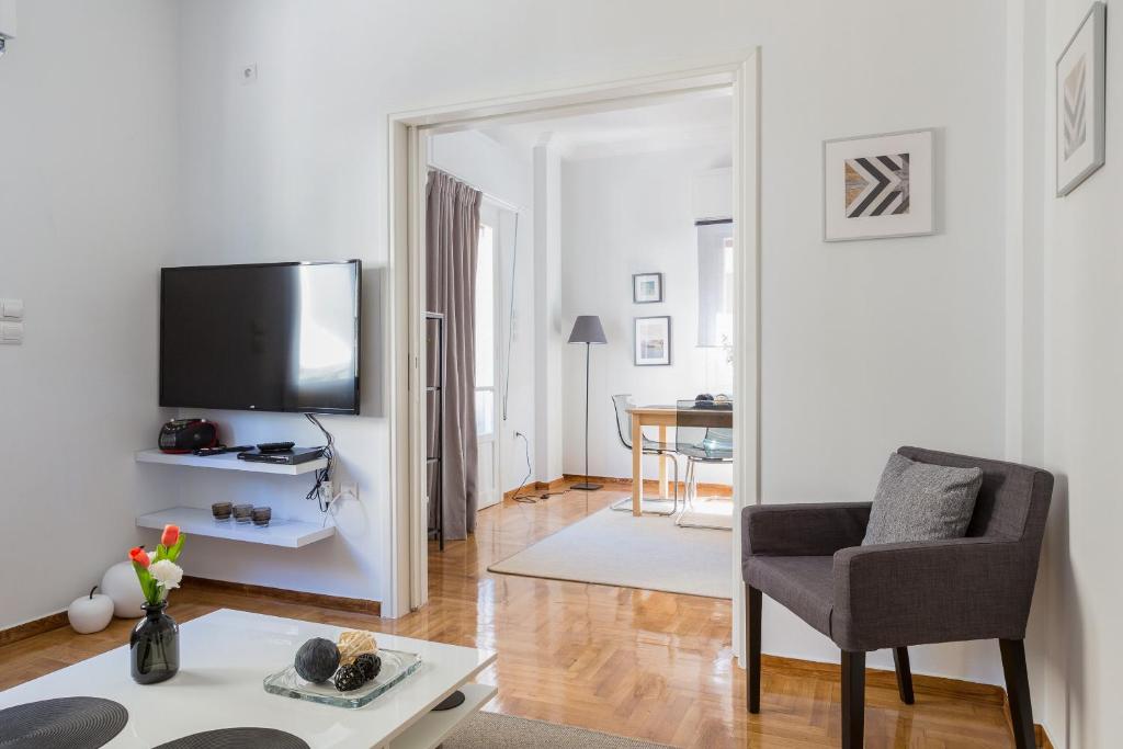 a living room with a chair and a television at Newly Renovated 100m² Stylish Urban Flat in Athens
