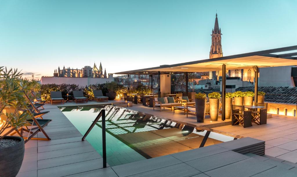 a rooftop patio with a pool on a building at Sant Francesc Hotel Singular in Palma de Mallorca