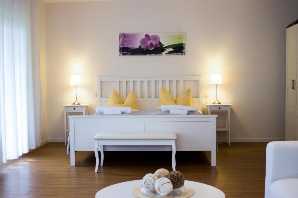 a bedroom with a white bed with yellow pillows at Appartementhaus Martin in Badenweiler