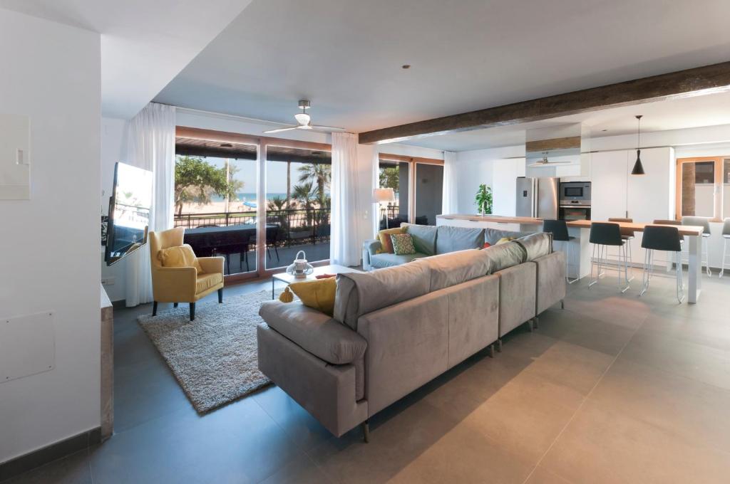 sala de estar amplia con sofá y cocina en Ag Casa Del Mar Premium, en Gandía