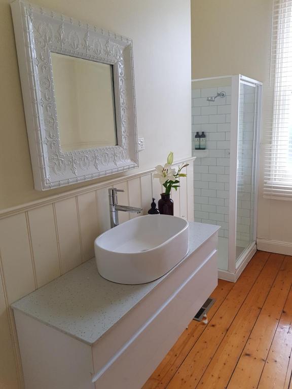 a bathroom with a large white sink and a mirror at Myers CBD in Bendigo