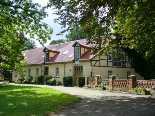 ein großes Haus mit einem Zaun vor einem Hof in der Unterkunft Hotel Garni Graf von Oberg in Lahstedt