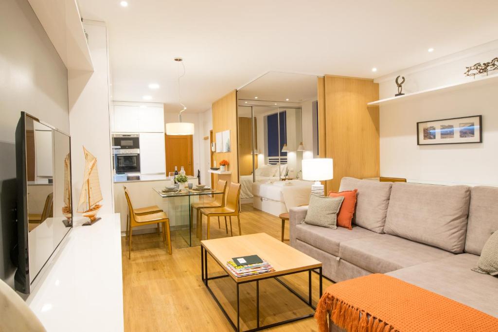 a living room and kitchen with a couch and a table at Merc Porto Cedofeita Place in Porto