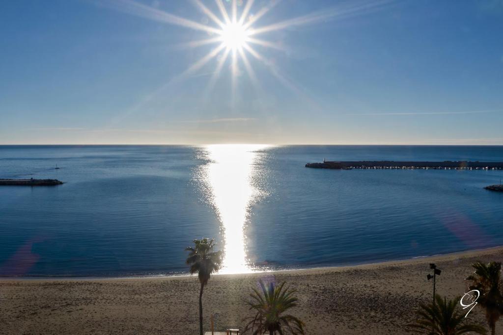 フエンヒロラにあるApartamentos Jaen 8-Fuengirolaの水上に太陽が輝く海岸