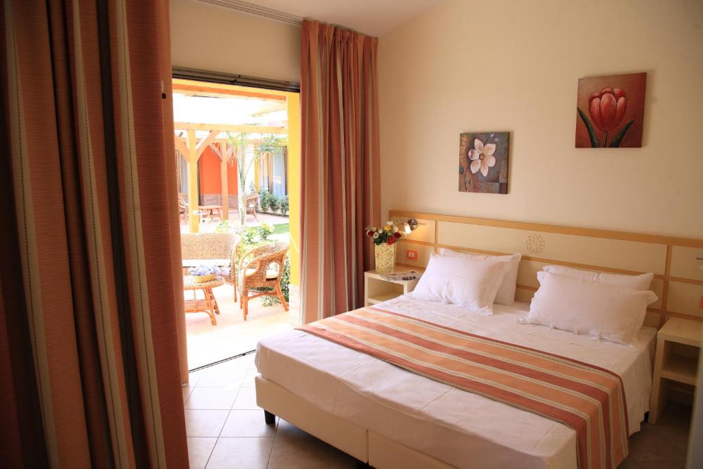 a hotel room with a bed and a balcony at Hotel Baia Di Trainiti in Briatico