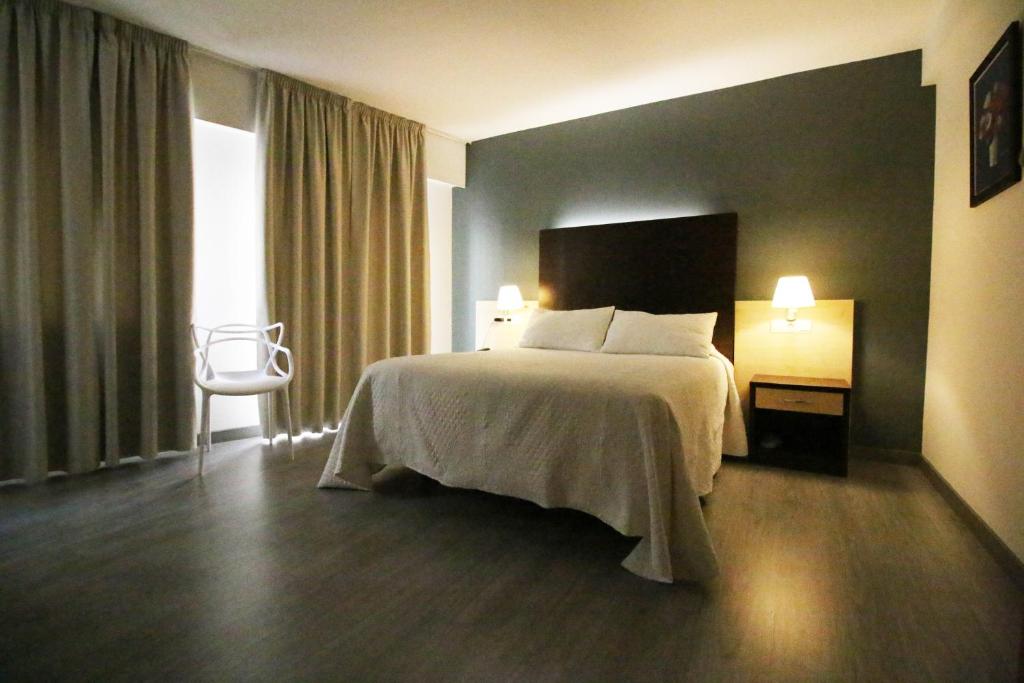 a hotel room with a large bed and a large window at Nest Style Santiago in Santiago de Compostela