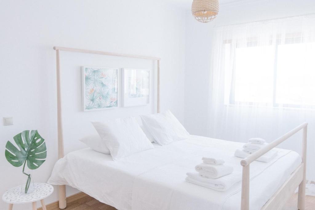 オリョンにあるCasas de Mar - Sereiaの白いベッドルーム(白いベッド1台、植物付)