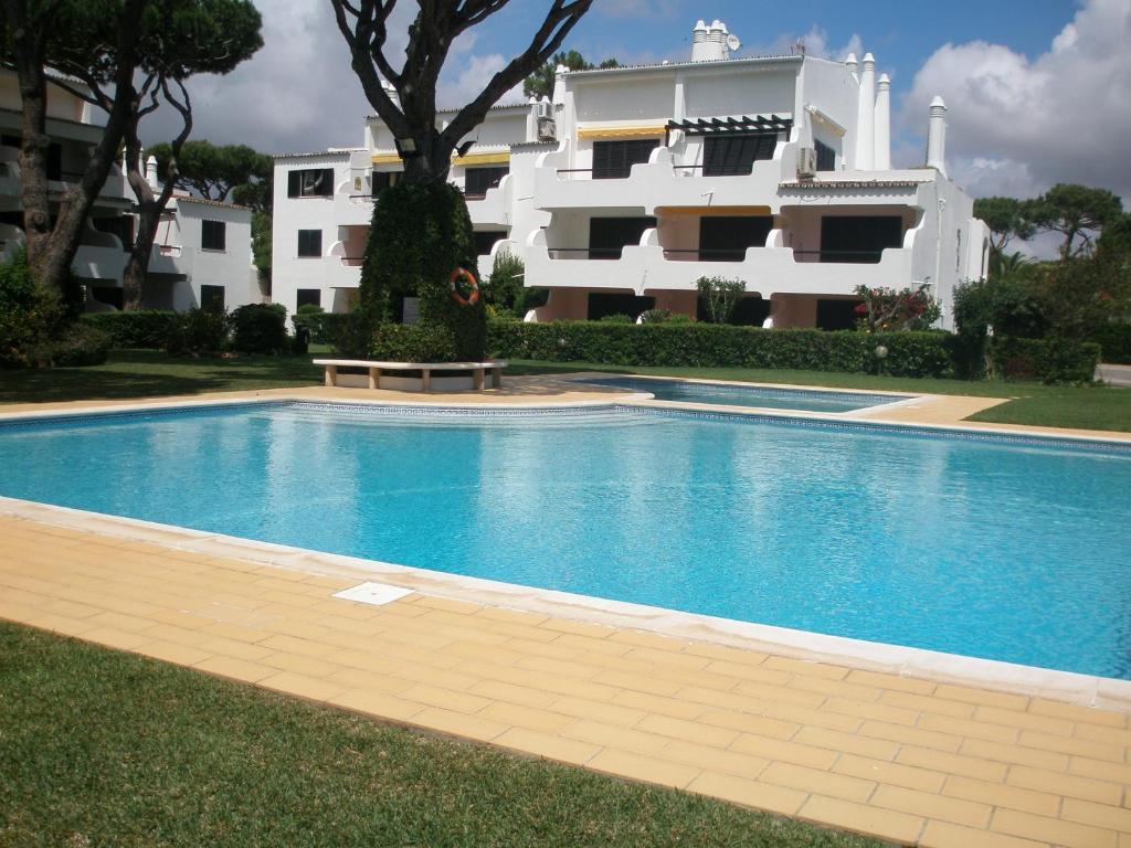 a swimming pool in front of a building at A Apartmento Solar dos Pinheiros in Vilamoura