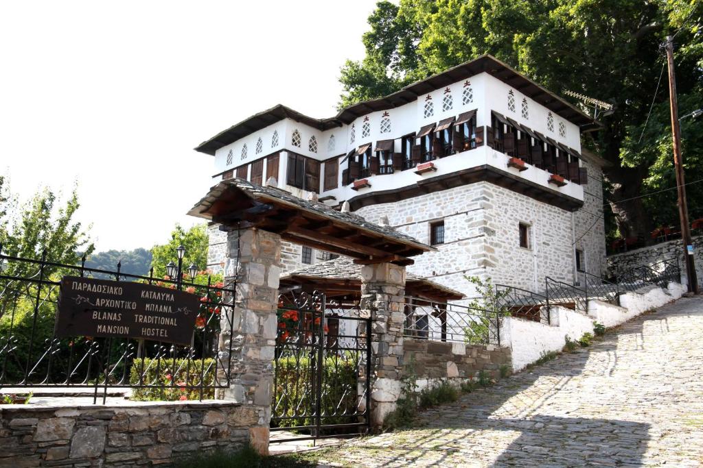 a large stone building with a sign in front of it at Archontiko Blana in Vizitsa