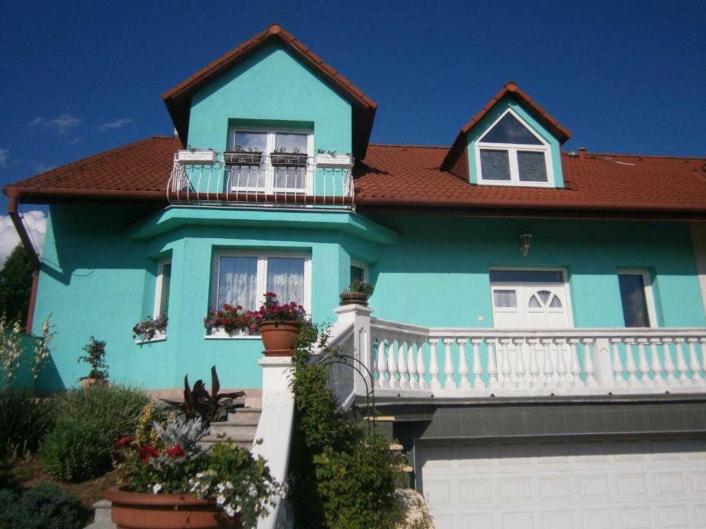 a blue house with a balcony at Azalka Penzion in Brno
