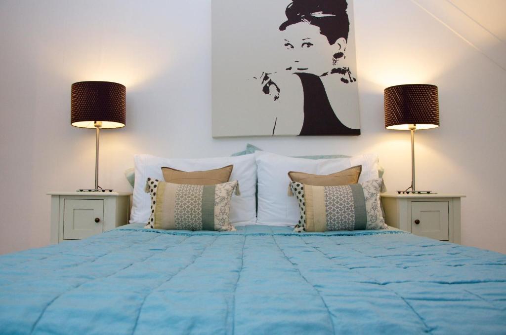 a bedroom with a blue bed with two lamps at Onefifty in Cowes