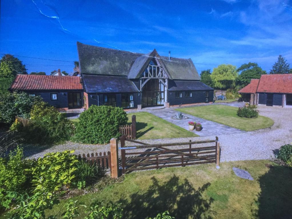 a large house with a fence in front of it at South Barn in Stanningfield