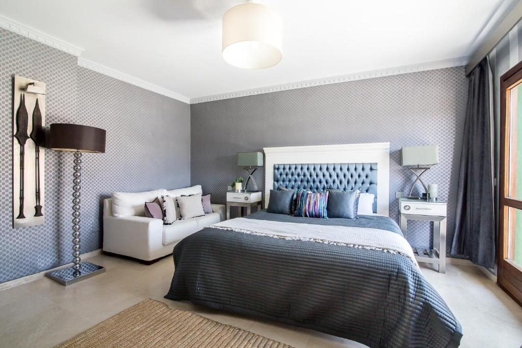 1 dormitorio con 1 cama grande y 1 sofá blanco en Villa Simvid Marbella, en Marbella