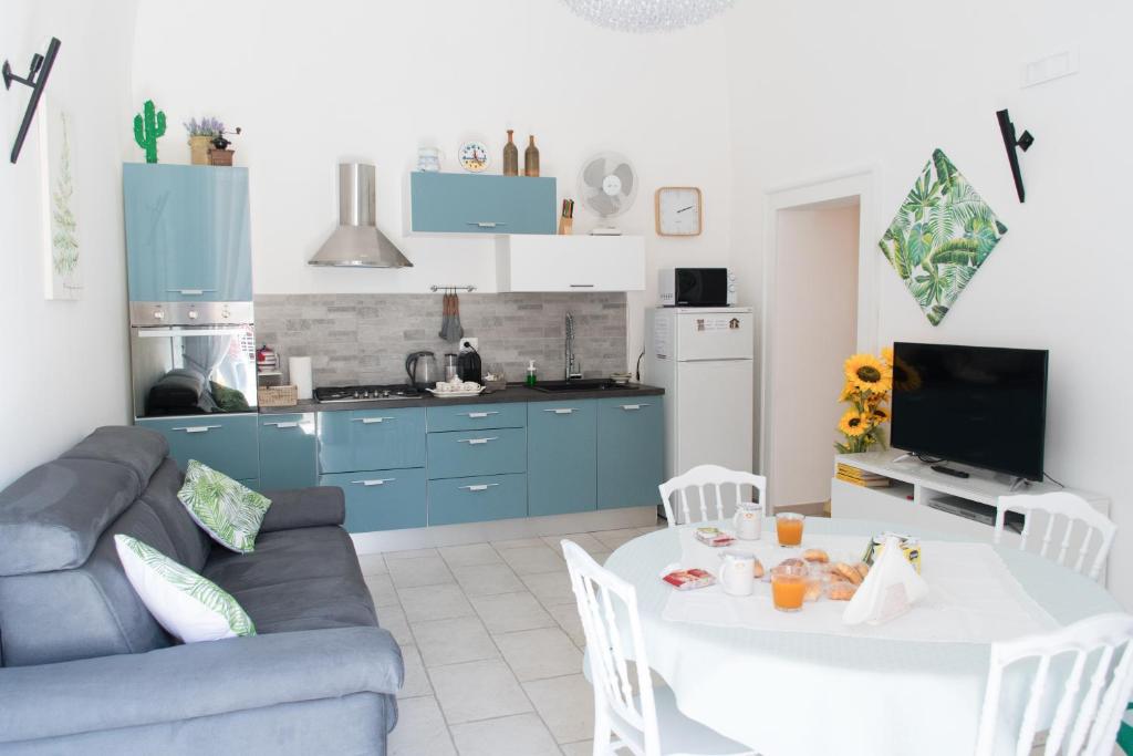 cocina y sala de estar con mesa y armarios azules en Casa Bianca, en Giovinazzo