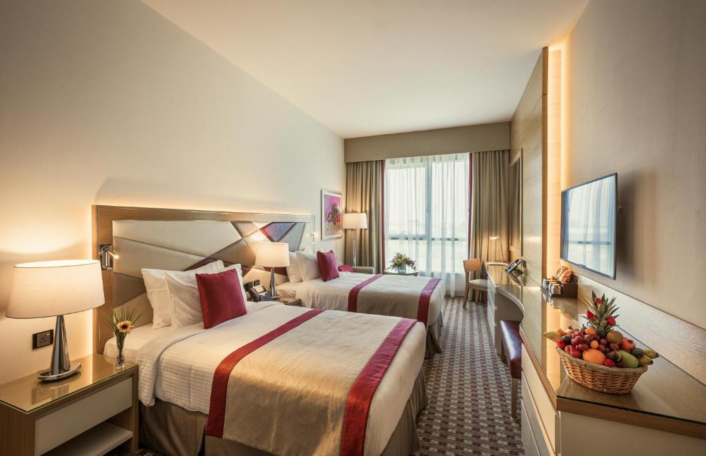 Gulf Inn Hotel Al Nasr Formerly Roda Links Al Nasr في دبي: غرفة فندقية بسريرين ونافذة