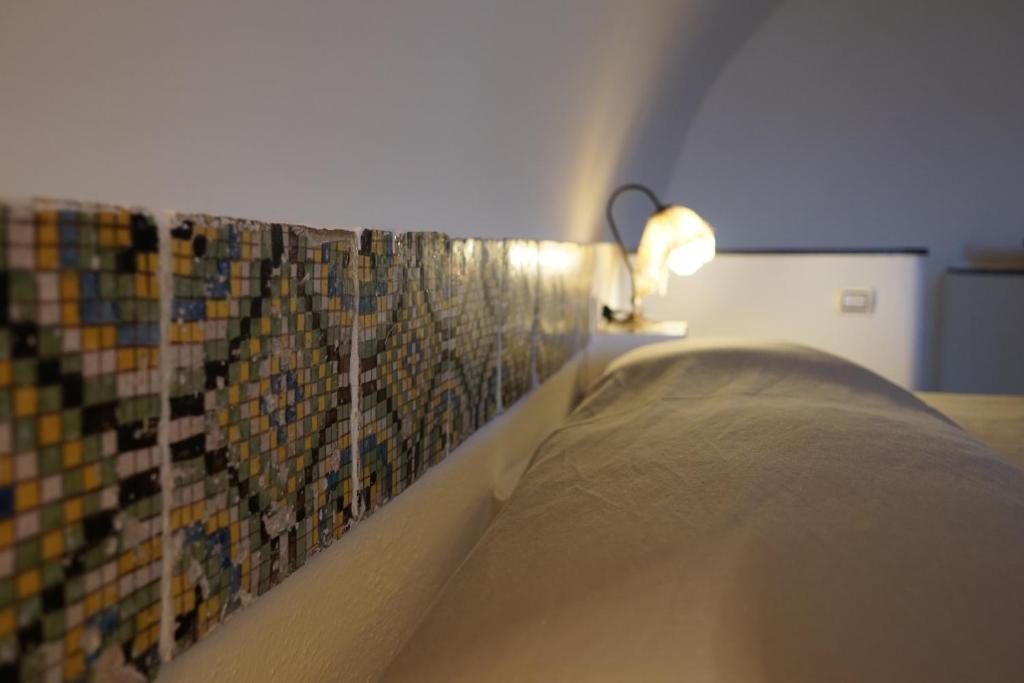 a bedroom with a bed and a wall with a lamp at Bella Baia Relais in Maiori