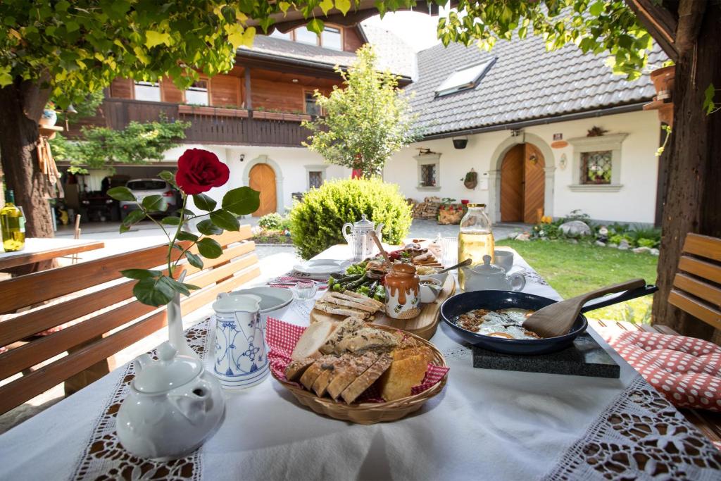 una mesa con comida y una cesta de pan en Apartmaji Katrnjek, en Bohinj