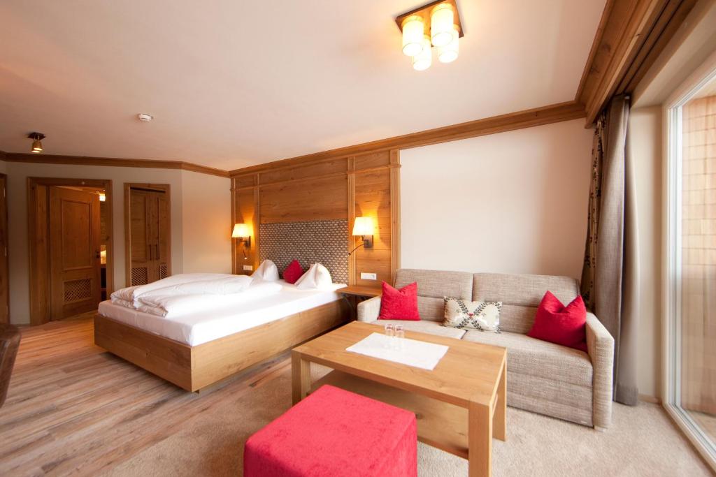 - une chambre avec un lit et un canapé dans l'établissement Hotel Sonnenhof, à Grän