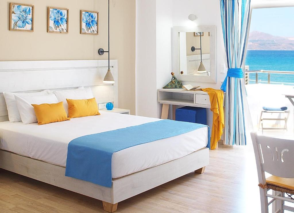 a bedroom with a bed and a view of the ocean at Almiris Seaside Apartments in Almirida