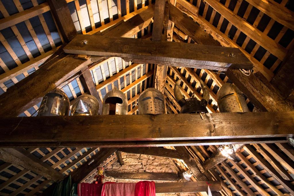 eine Holzdecke mit Glocken auf einem Regal im Dachgeschoss in der Unterkunft Authentic Knight's Templar Chamber at Chateau Le Mur in Carentoir