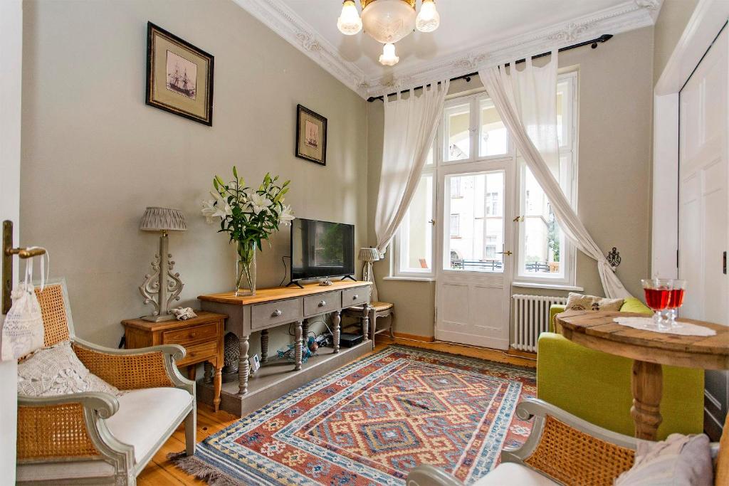 un soggiorno con televisione, tavolo e sedie di Parkowa 1902 moj-sopot pl a Sopot