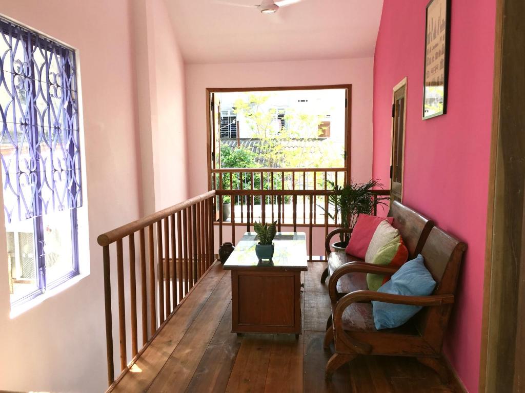 a living room with pink walls and a chair at The Bohome in Quy Nhon