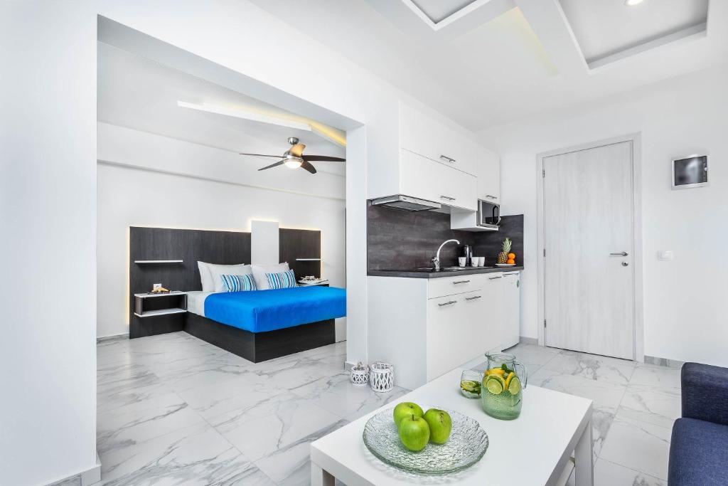 eine Küche und ein Wohnzimmer mit einem blauen Sofa in der Unterkunft Asterias Premium Holiday Apartments in Pefkohori