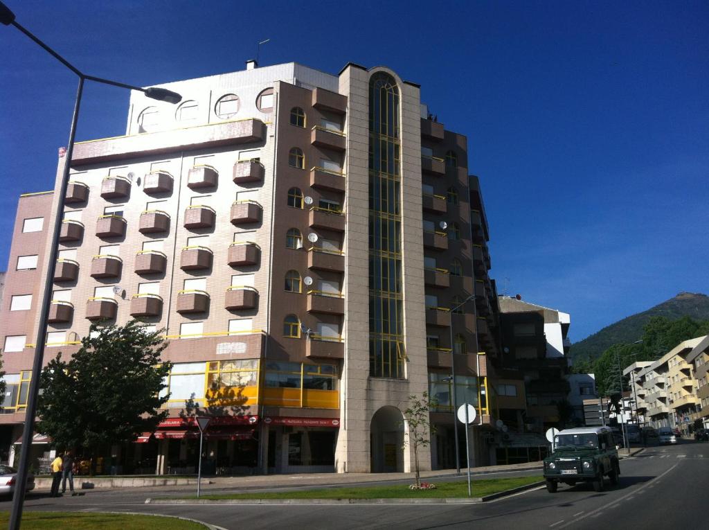 a tall building on a city street next to a road at Casa do Rodrigo in Mondim de Basto