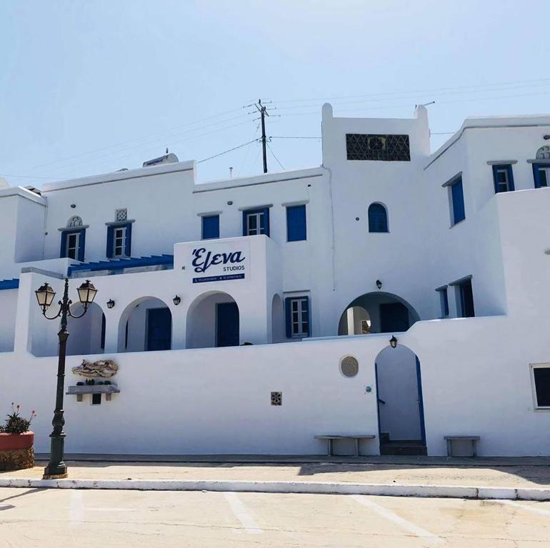 a white building with a sign on it at Elena Studios in Panormos