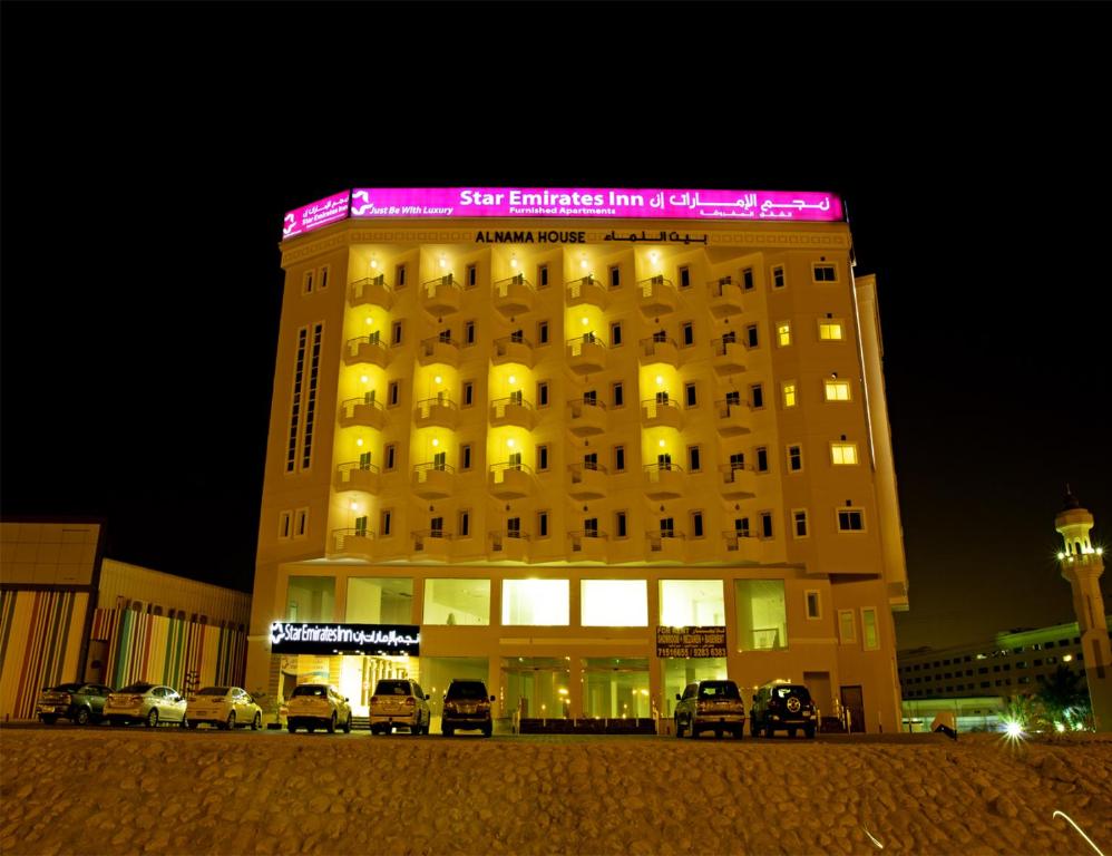 a building with cars parked in front of it at night at Star Emirates Inn in Salalah