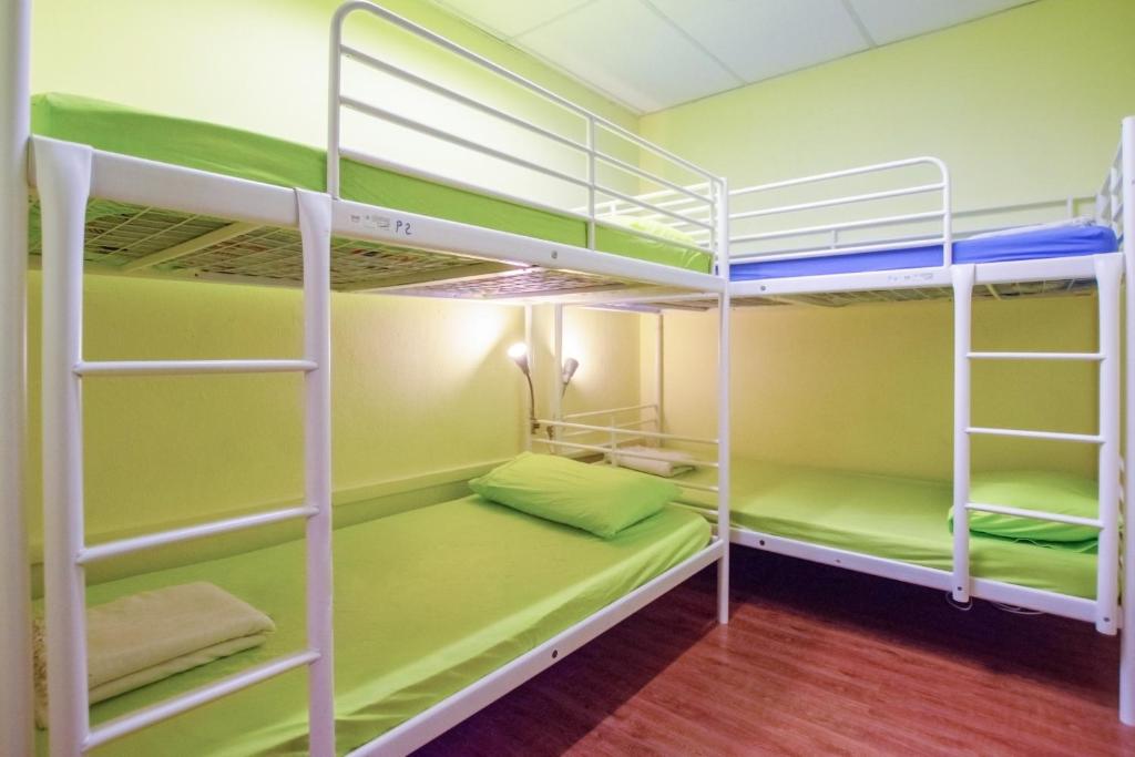 a bunk bed room with green and white bunk beds at Vintage Inn at Clarke Quay in Singapore