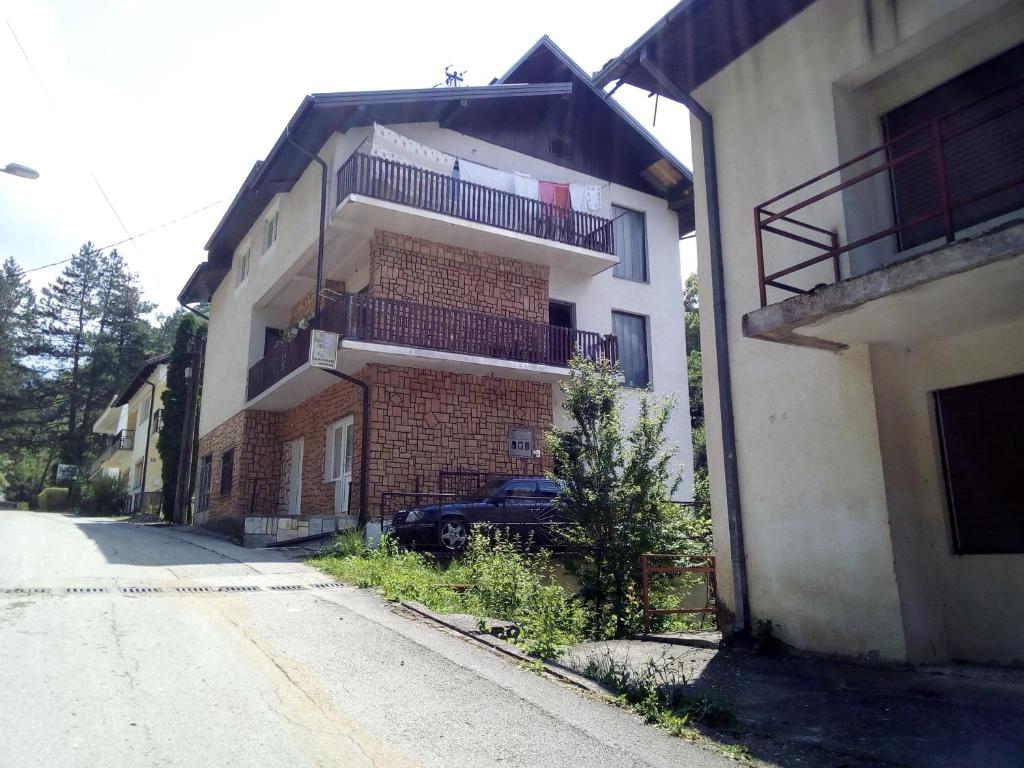 a building with a car parked next to a street at HM - konak in Srebrenica