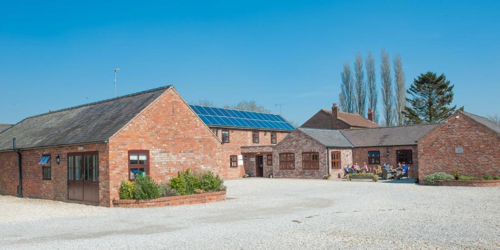 a large brick building with a parking lot at Wold Escapes, Highfield Farm in Great Driffield