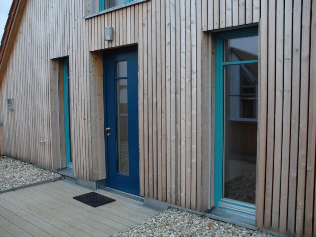 un edificio con porte blu e pavimento in legno di Ferienwohnung Passivhaus "Schöne Aussicht" a Georgensgmünd