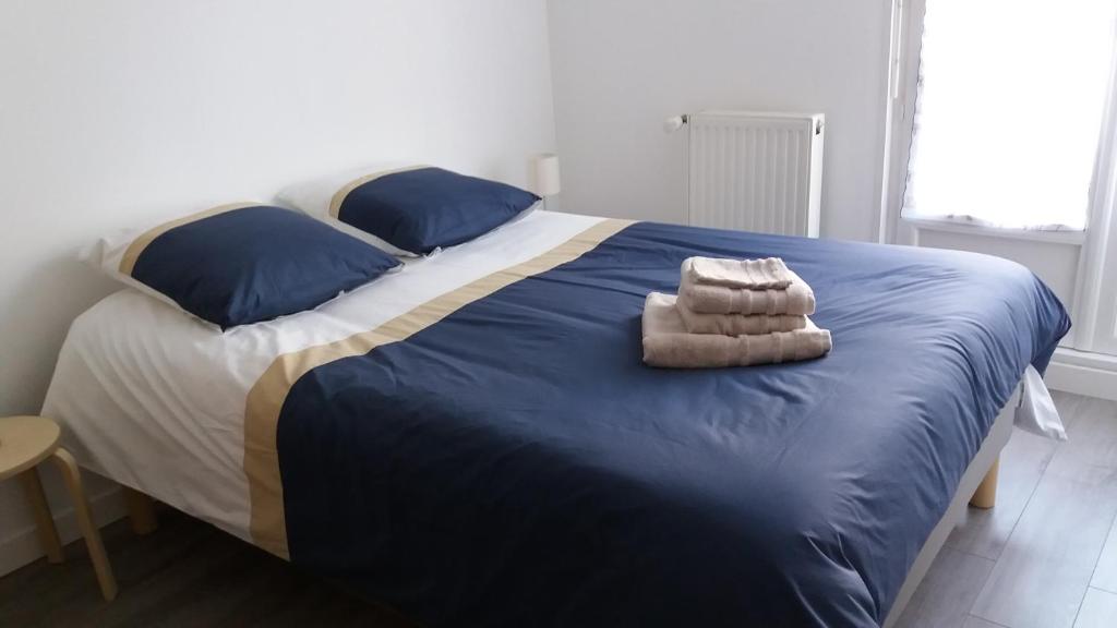 - une chambre avec un grand lit doté de draps bleus et d'oreillers bleus dans l'établissement Le Vivier appartement avec parking, à Boulogne-sur-Mer