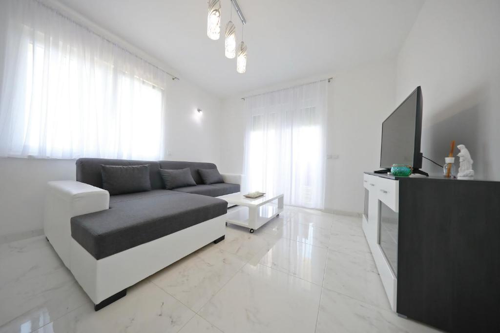 Televízia a/alebo spoločenská miestnosť v ubytovaní Apartmani Vlado Mitar