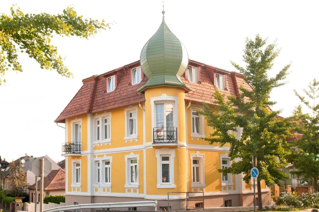 un edificio amarillo con una torreta encima en Villa Lucia, en Hévíz