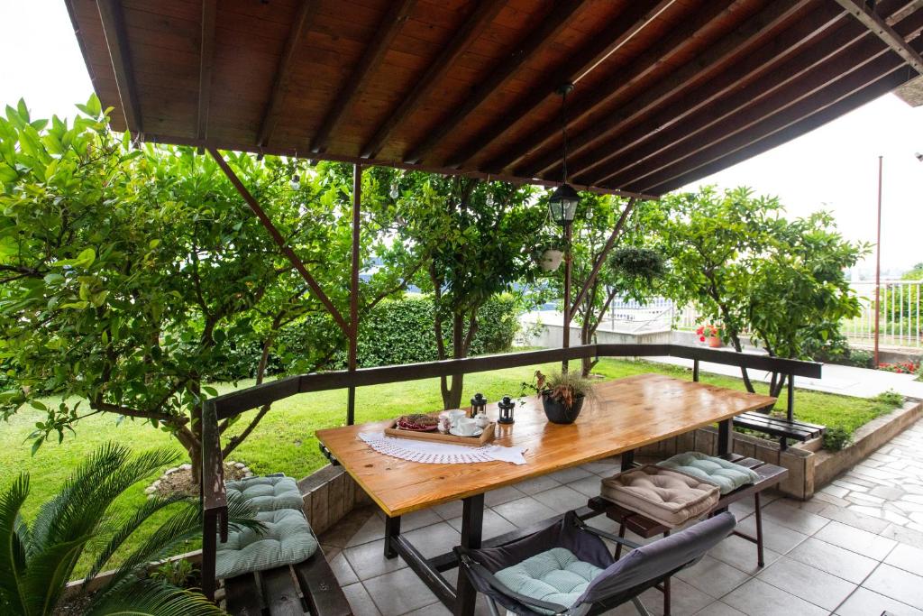 a wooden table and chairs on a patio with trees at Zeleni kuk in Solin