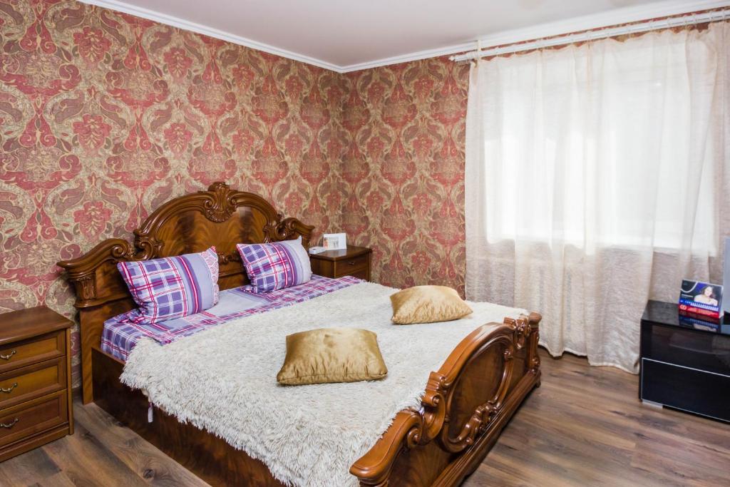 a bedroom with a bed with pillows on it at Apartment on 50 let Oktyabrya 51 TyumGNGU in Tyumen