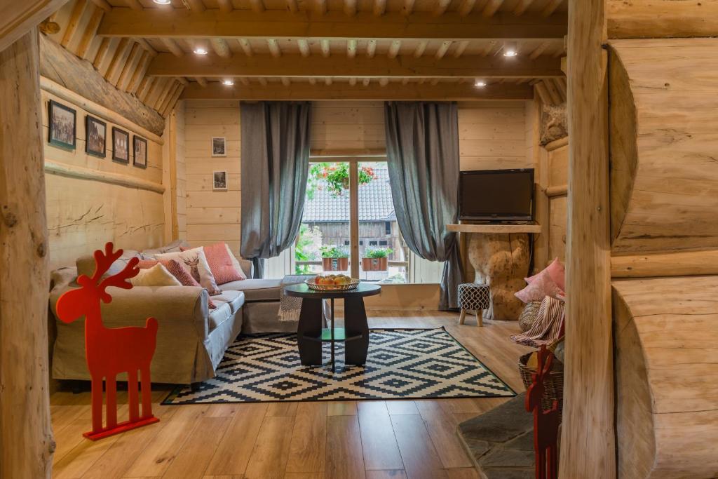 a living room with a couch and a table at Domek Szałas pod Dębem in Ząb