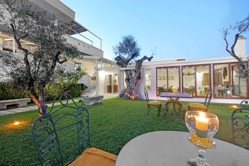 un patio al aire libre con mesa y sillas y un edificio en Residence Contrada Schite, en Presicce