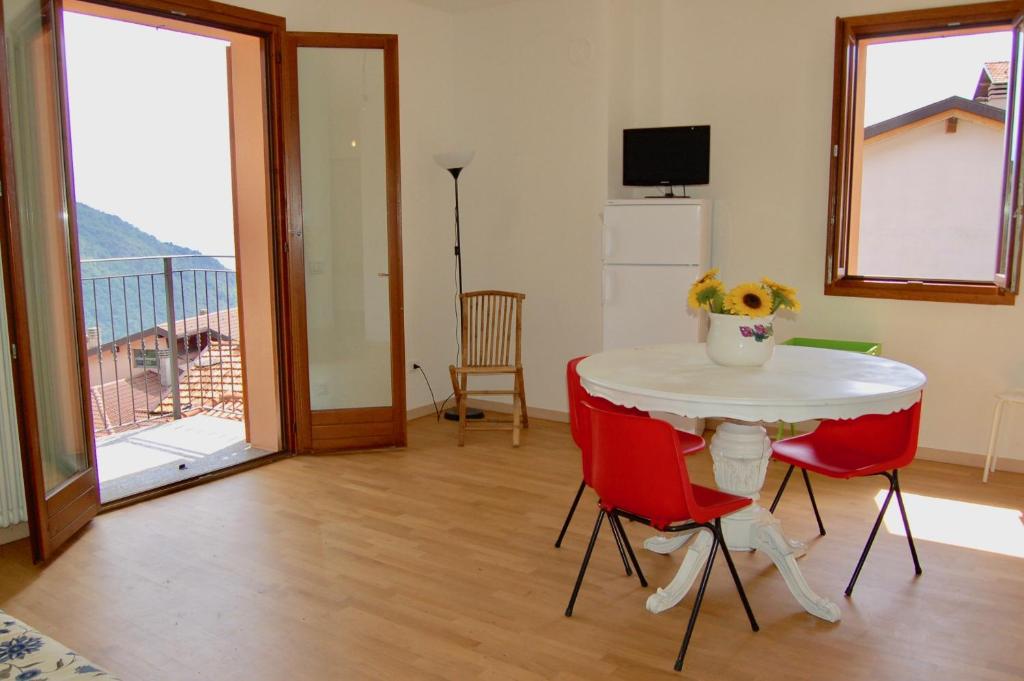 a living room with a table and red chairs at Casa Patrizia in Sueglio