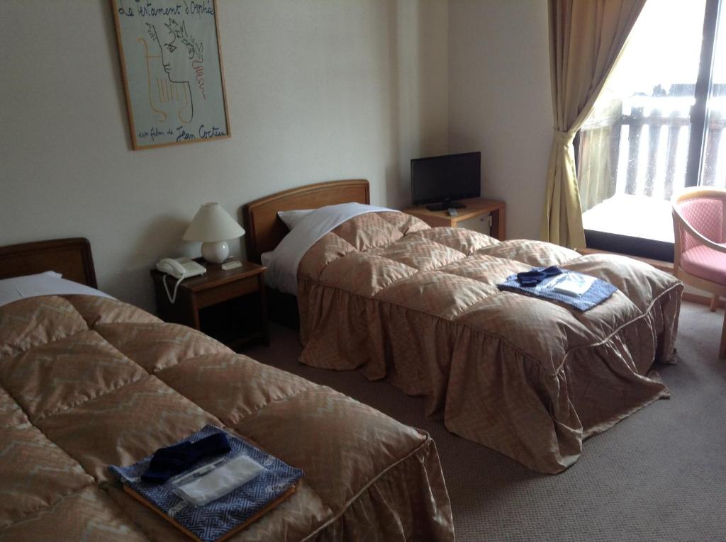 Postel nebo postele na pokoji v ubytování Hakuba Alpine Hotel