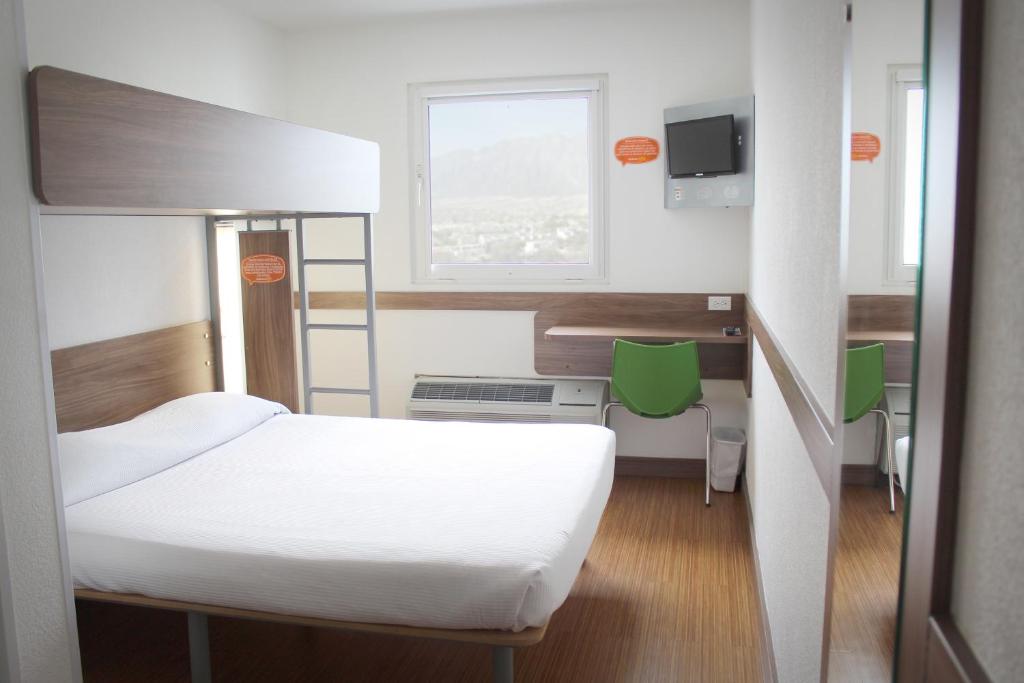 a small room with a bed and a window at Hotel Hi! Santa Catarina in Monterrey