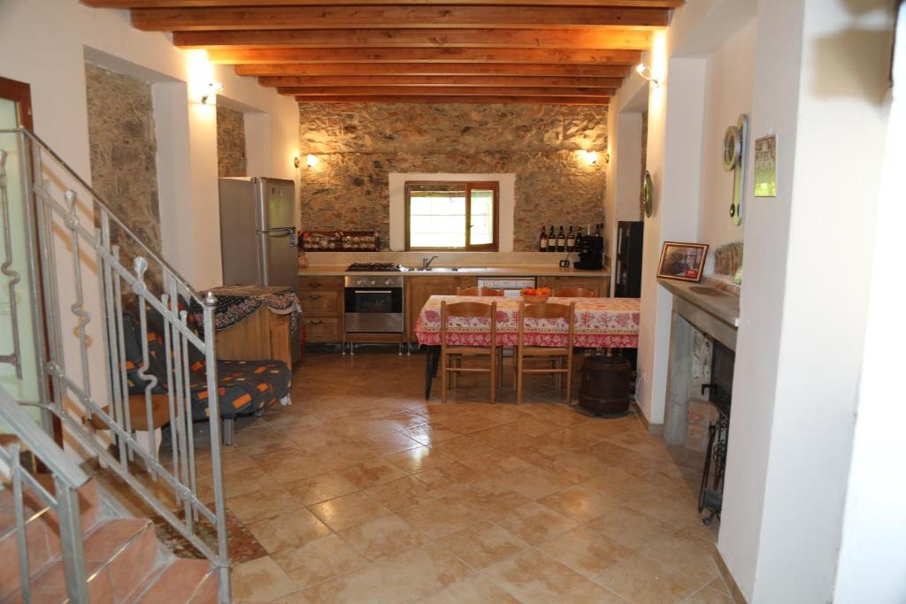 una cucina e una sala da pranzo con tavolo di Cozy villa with garden a Toirano