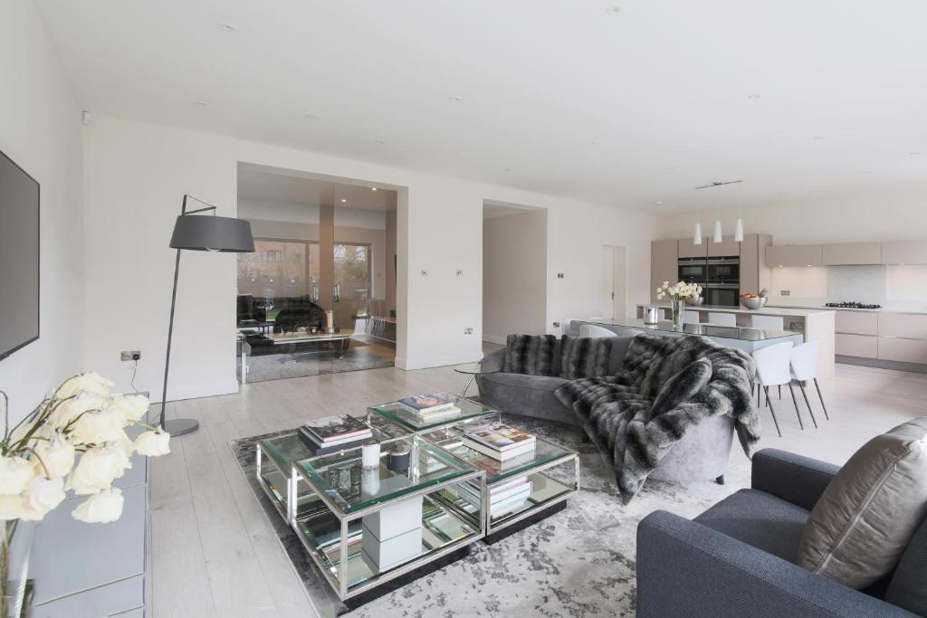 a living room with a couch and a glass table at House for Wimbledon Tennis in Raynes Park